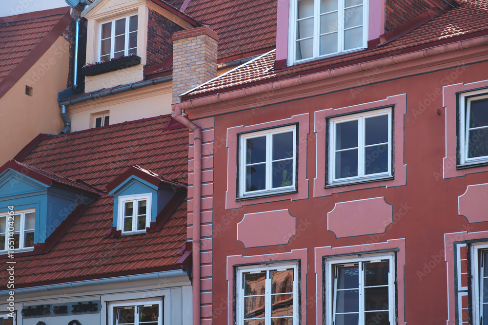 Fototapeta premium Row of houses with pink building in the middle. All houses are different colors and styles. Riga vacation travel concept