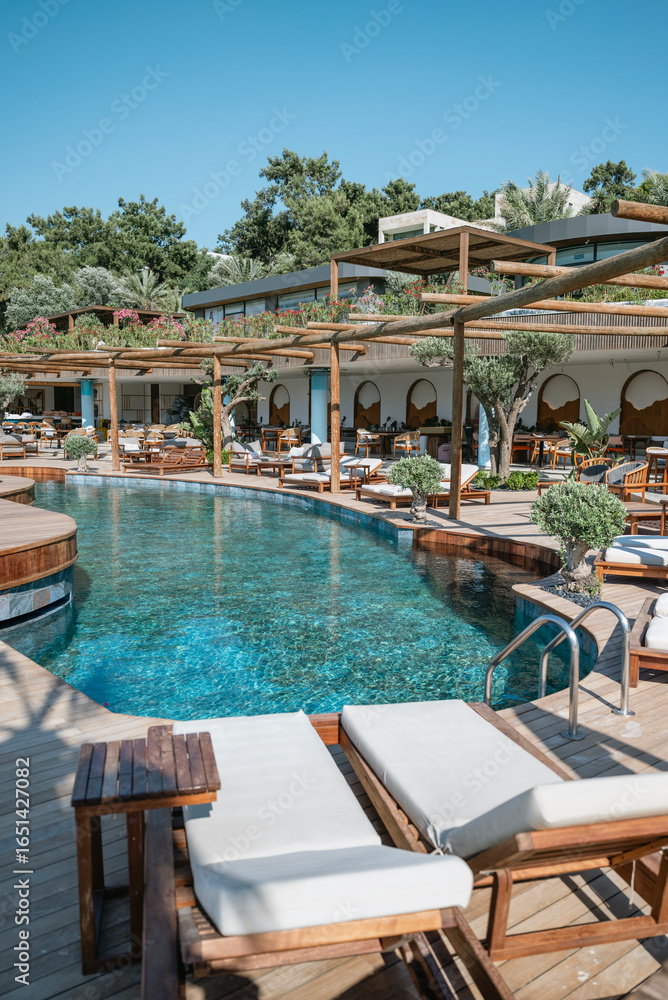 Fototapeta premium Empty deck chairs around outdoor luxury swimming pool