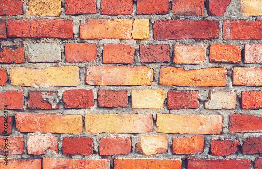 Obraz premium Background of uneven bricks of different sizes with cement joints. Texture close-up.