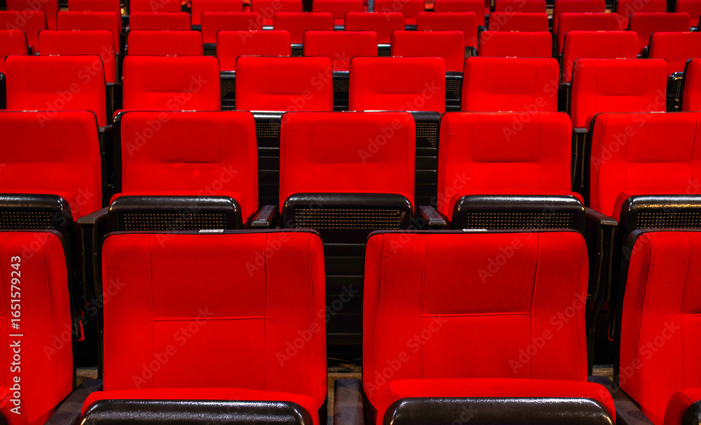 Fototapeta premium Rows of red seats in an auditorium or cinema hall. Evokes entertainment, leisure, and culture.