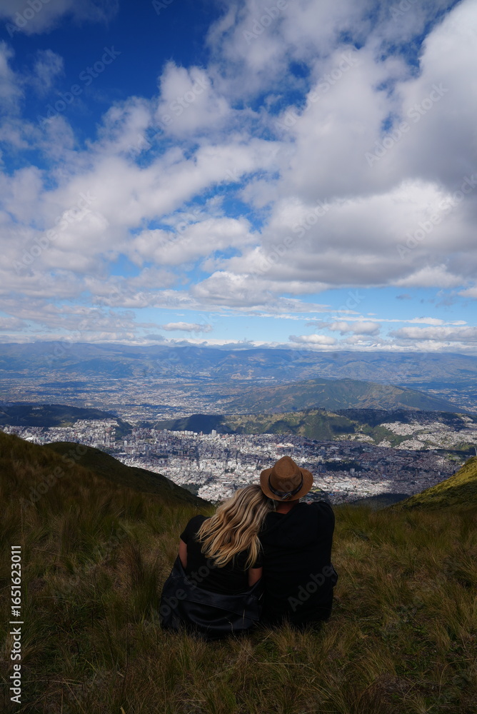Fototapeta premium Couple Sitting On Top Of A Mountain