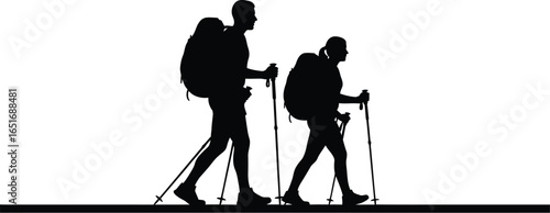 Silhouette of two hikers with backpacks and trekking poles walking a trail