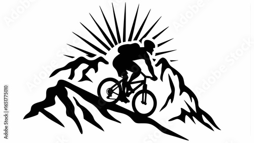 Silhouette of a mountain biker riding on a mountain ridge with sun rays shining from behind the mountains