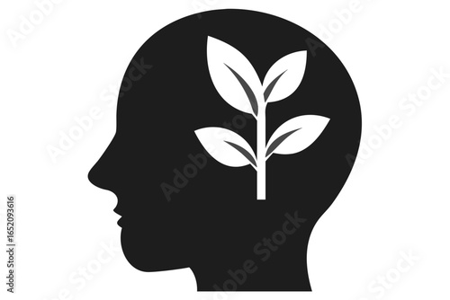 Silhouette of a human head with a growing plant inside on a black background growth mind