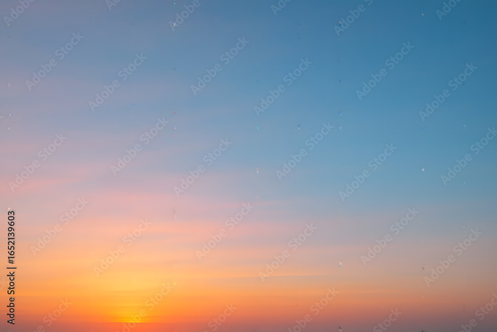 Naklejka premium Sky Sunset: A stunning scene painted across the sky, with the gradient blending of orange and blue, creating an inspiring sunset, a moment of reflection and peace