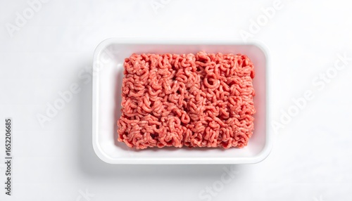 Fresh ground beef in a white styrofoam tray, top-down view on a white surface.