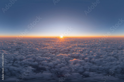 Sunrise over clouds with golden light and blue sky atmosphere aerial