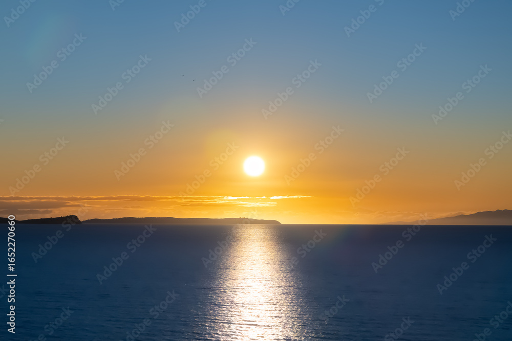 Naklejka premium Winter sunrise over the ocean at Long Bay, Auckland