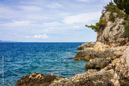 Photography A cliff by the sea with a view of the mountains