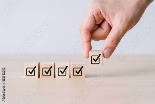 Hand placing a wooden block with a checkmark. Concept of tasks completed, checklist, and approval.