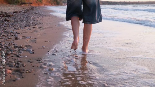 A girl walks by the sea