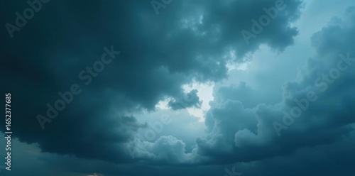 Dense, grey storm clouds loom overhead, a dramatic low angle , shadow, rain
