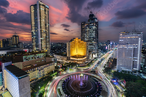 Jakarta skyline taken in a fantastic blue hour, with the big roundabout that hold the iconic welcome monument and the skyscrapers in the background 

