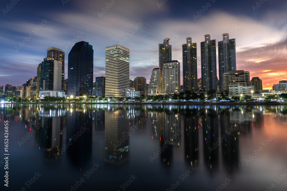 Obraz premium Bangkok Skyline with skyscrapers reflections taken at sunrise from Benjakitty Park 