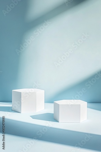 Two White Geometric Display Stands On A Light Blue Surface