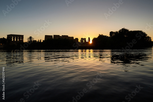 The silhouette of the temples on the island of Philae seen from the Low Aswan Dam at sunset