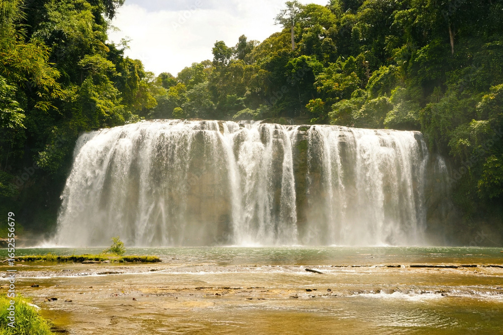 Obraz premium Majestic Waterfall Cascading into a Serene Pool Surrounded by Lush Greenery