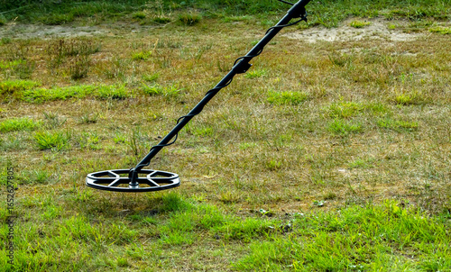 a man walks through a field with a metal detector