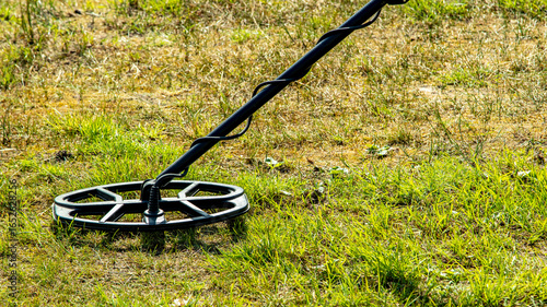 a man walks through a field with a metal detector