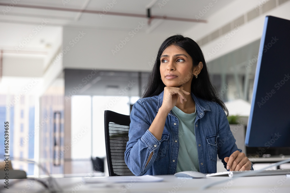© fizkes - Thoughtful successful young female Indian company worker in casual sitting at pc monitor at workplace, looking away, thinking on job task, creative idea for startup, planning strategy © fizkes - Thoughtful successful young female Indian company worker in casual sitting at pc monitor at workplace, looking away, thinking on job task, creative idea for startup, planning strategy