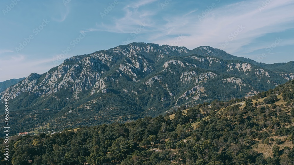 Naklejka premium Beautiful natural panorama showcasing a mountain range with vibrant greenery and blue horizon