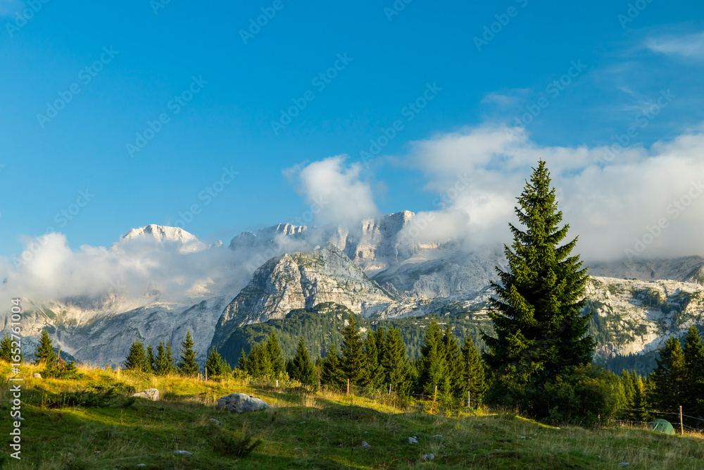 Obraz premium Majestic Mountain Peaks Rising Above a Serene Valley in the Julian Alps