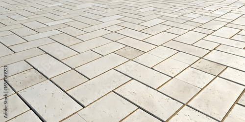 Light beige rectangular stone pavers arranged in herringbone pattern, featuring smooth surfaces with minimal texture and consistent coloring.