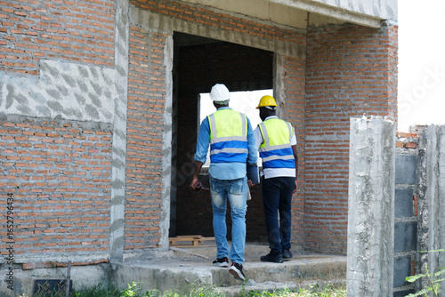 Wallpaper Mural Male engineer and construction worker working at a construction site. Torontodigital.ca