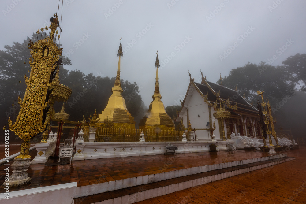 Fototapeta premium The background of the religious tourist attraction Wat Phra That Doi Tung in the mist in Chiang Rai Province, Thailand, where travelers often stop to make merit.