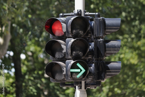 Red traffic light with green arrow signal for right turn.