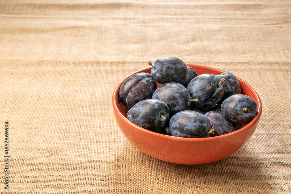 Sweet black plum on jute cloth, macro. Sweet black plum on jute cloth, macro.