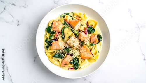 Creamy salmon pasta with spinach in a white bowl