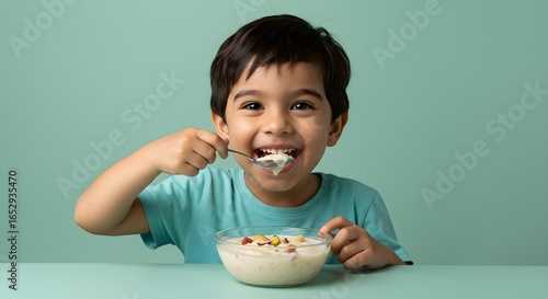 Happy Boy Eating Kheer or Rice Pudding with Nuts