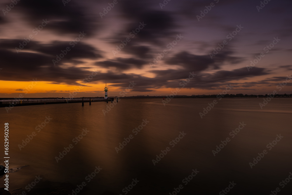Obraz premium Beautiful sunrise at the lighthouse on Timmendorfer Strand.