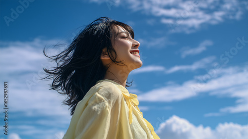 日本人少女が青空を見上げ笑顔