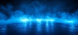 Mysterious blue neon lights illuminate a smoky wet asphalt surface creating dramatic reflections on a dark atmospheric background