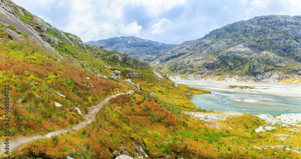Fototapeta premium a hiking path through the tundra in high altitude mountain with glacier water, Norway summer, hiking experience