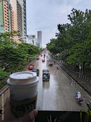 Drinking coffee over a busy street in Quezon city after the rain has stopped