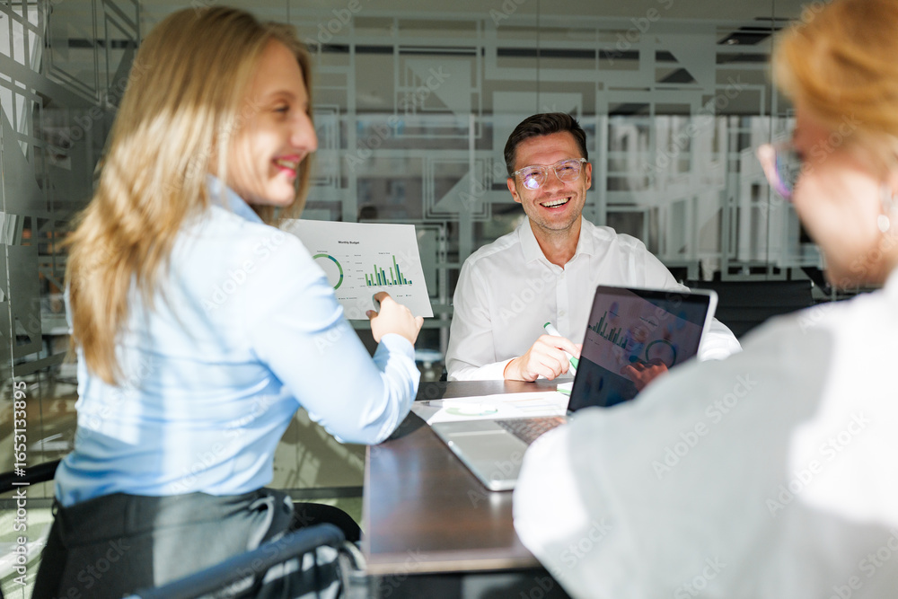 Fototapeta premium Team members engage in strategic discussions while reviewing data insights in a modern office environment