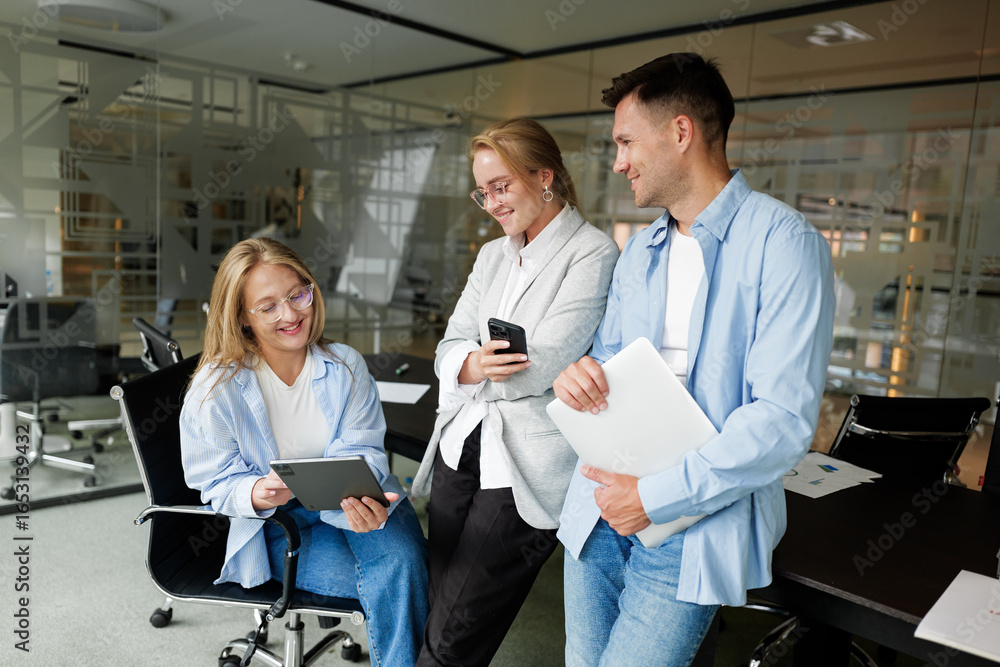Fototapeta premium Engaging discussion people among colleagues in a modern office setting while sharing ideas on a digital tablet