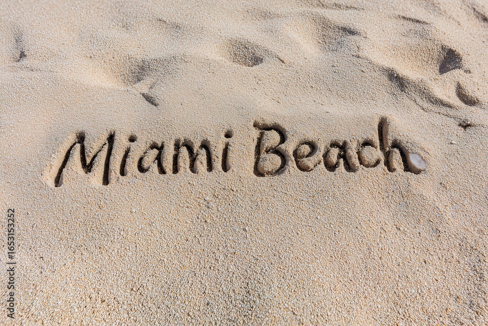 Fototapeta premium Miami Beach Text Carved Into Sand On A Sunny Day In Florida Vacation Destination