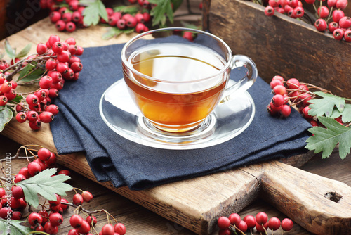 Foto Haw thorn autumn berry tea in a glass cup on rustic background, red herbal drink