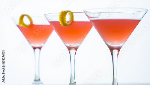 Wallpaper Mural Three Cosmopolitan Cocktails Garnished with Lemon Peels Against a Bright White Background Elegant and Refreshing Drinks Torontodigital.ca