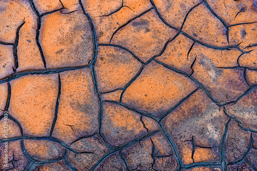 Cracked Earth Texture with Orange and Blue-Gray Colors