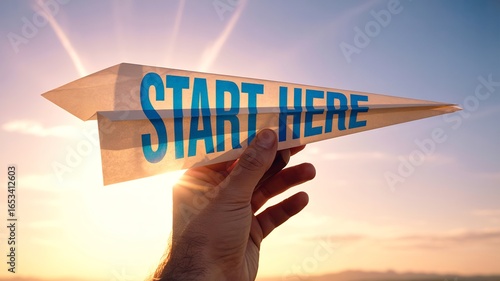 Wallpaper Mural Hand holding a paper airplane with start here written on it against a bright sunny sky Torontodigital.ca