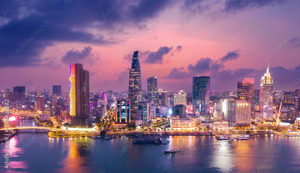 Fototapeta premium Aerial view panoramic of Ho chi minh or Saigon city at sunset in Vietnam, illuminated skyscrapers with sunlight