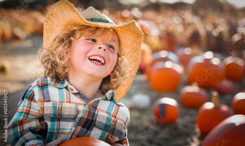 Фотография Cute Young Boy Wearing Cowboy Hat at Pumpkin Patch Farm.