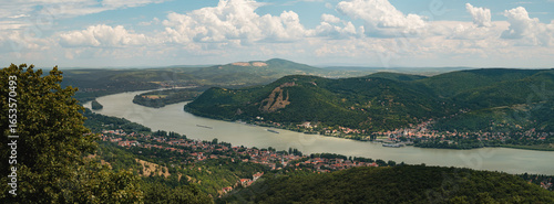 The Danube Bend unfolds in stunning beauty, with Visegrád Castle perched above and Nagymaros resting peacefully along the river’s edge under a bright summer sky