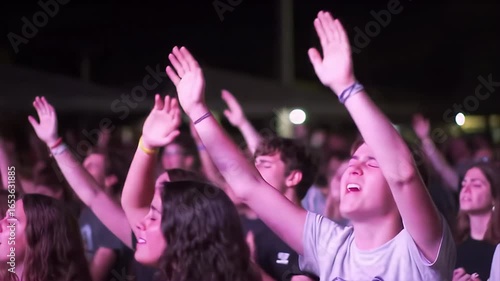 Enthusiastic crowd raising hands in worship or celebration at an outdoor event. The scene conveys energy, community, and a positive spiritual atmosphere. Suitable for faith-based or lifestyle topics