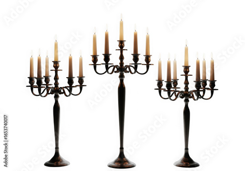 Three tall dark candelabras with lit candles isolated on transparent background